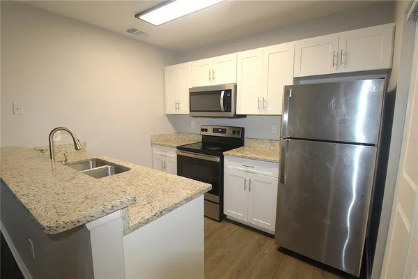 a kitchen with appliances a sink and a refrigerator
