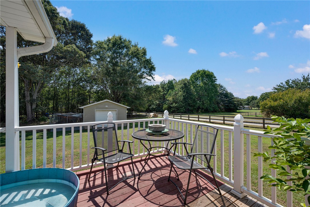 247 Clardy Road Pelzer, SC 29669 - Photo 23 of 34 A spacious elevated deck overlooks the sprawling grassy yard and surrounding trees.