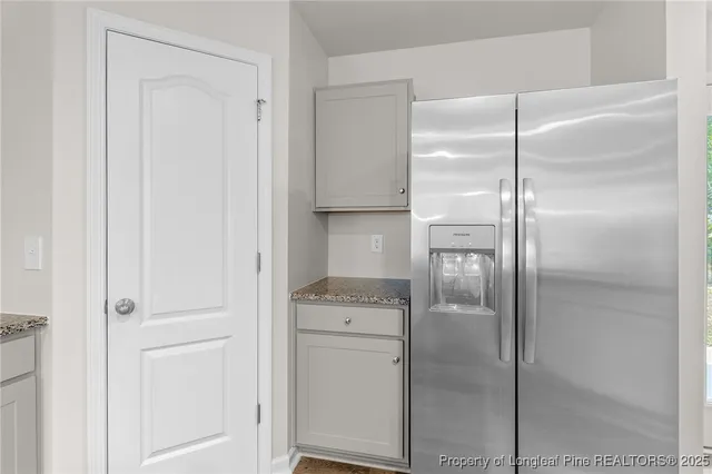 a walk in closet with wooden floor