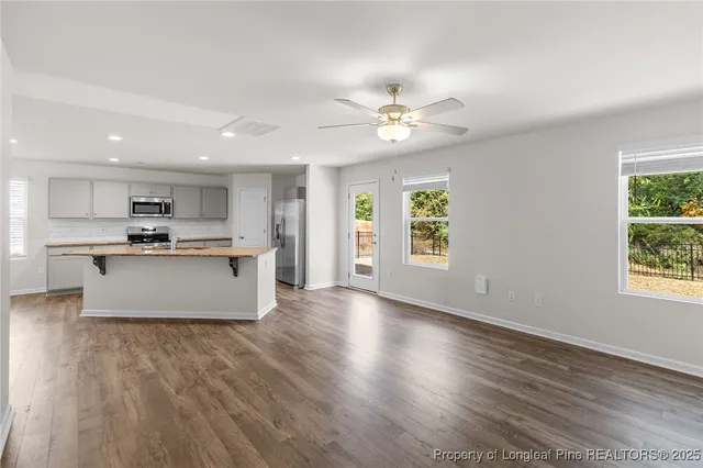 an open kitchen with granite countertop a stove top oven a sink dishwasher with a dining table and chairs