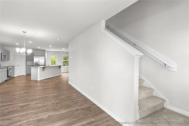 a view of an empty room with kitchen view and a window