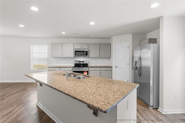 a kitchen with a center island and stainless steel appliances