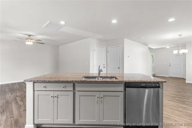 a kitchen with granite countertop a sink and cabinets