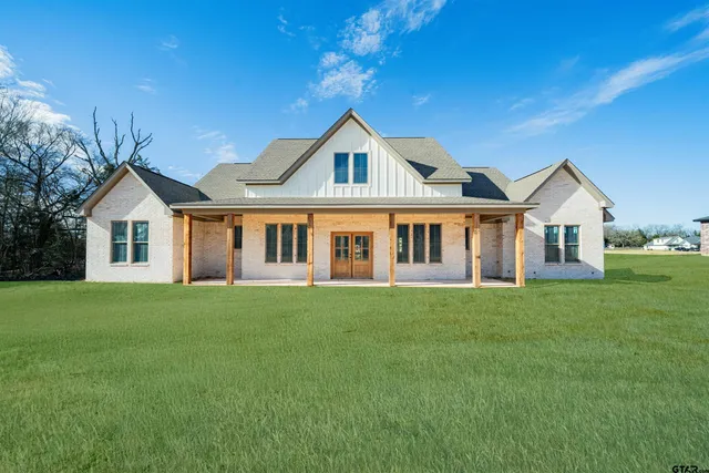 a view of a yard in front of a house with large trees