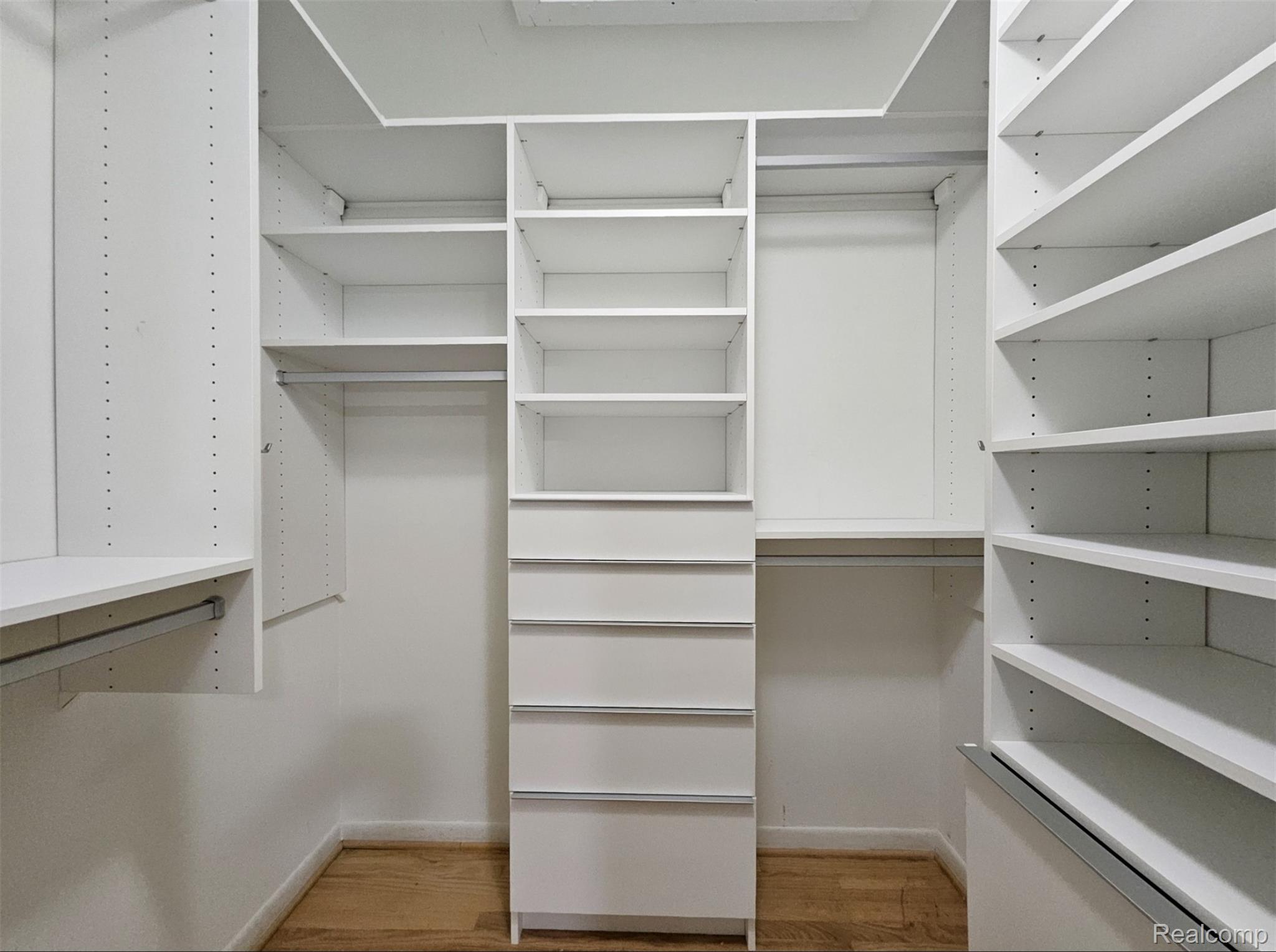 7120 Pebblecreek Road West Bloomfield, MI 48322 - Photo 20 of 31 Custom closet system featuring white built-in shelving, multiple hanging rods, and integrated drawers