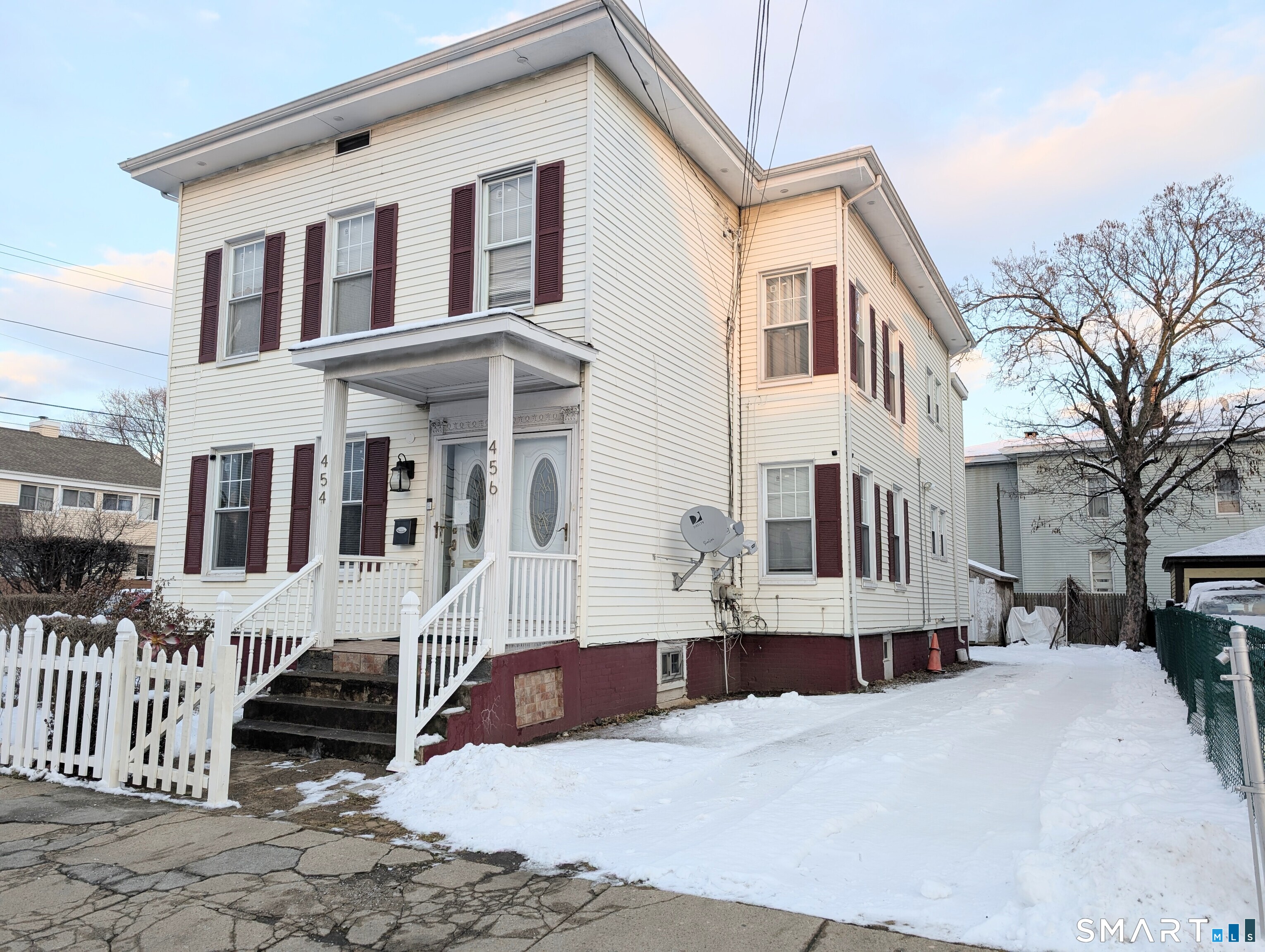 454 Pembroke Street Bridgeport, CT 06608 - Photo 2 of 40 a view of a white building among the street with palm trees