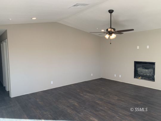 1536 Sims Street Ridgecrest, CA 93555 - Photo 4 of 19 an empty room with a chandelier fan and wooden floor
