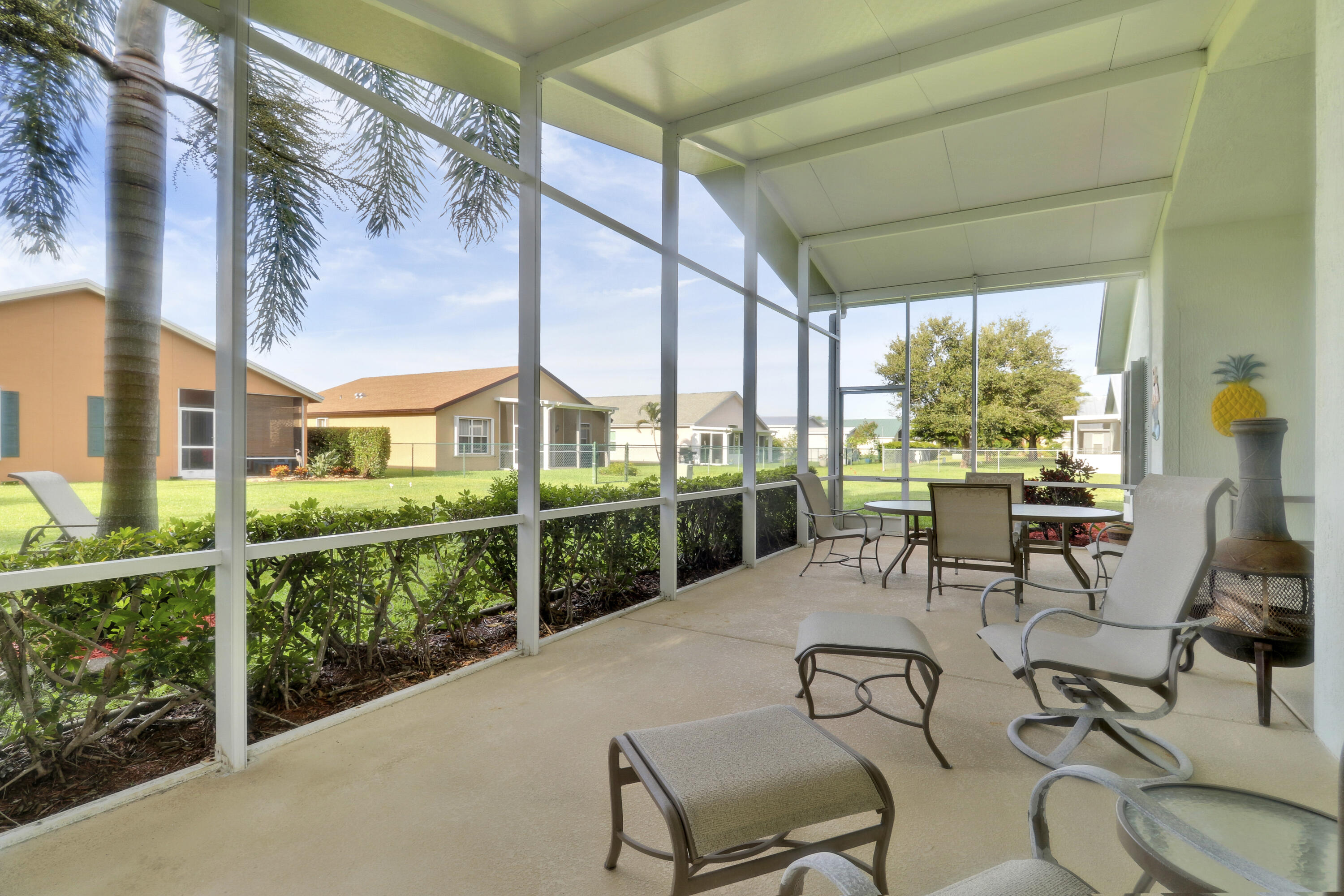 a view of a patio with table and chairs potted plants with wooden floor and fence