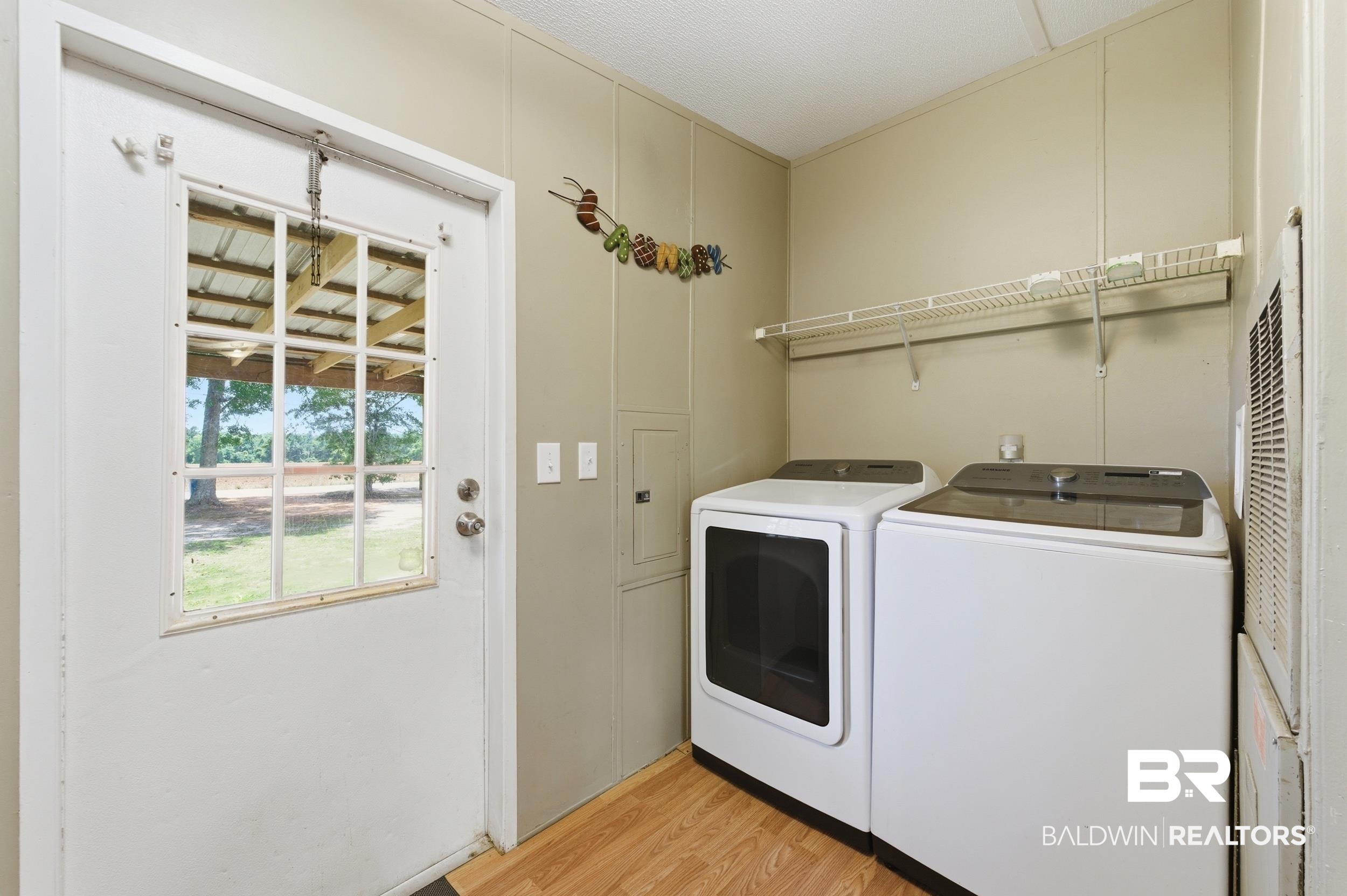 926 Tumbling Lane Atmore, AL 36502 - Photo 24 of 56 Utility area featuring wood-finish flooring and a white exterior door with a multi-pane window