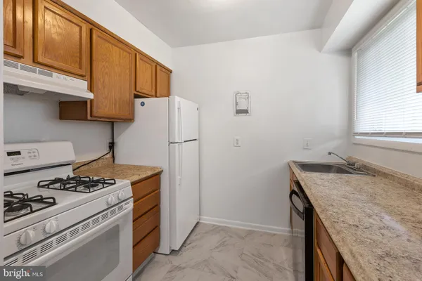 a kitchen with stainless steel appliances granite countertop a stove a refrigerator and a sink