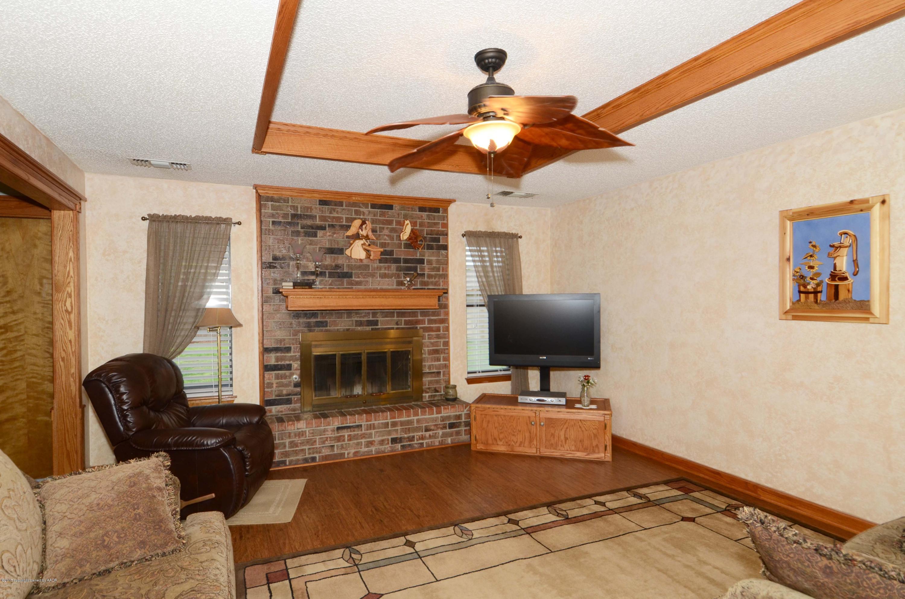8104 Leah Trail Amarillo, TX 79110 - Photo 2 of 22 a living room with furniture a fireplace and a flat screen tv