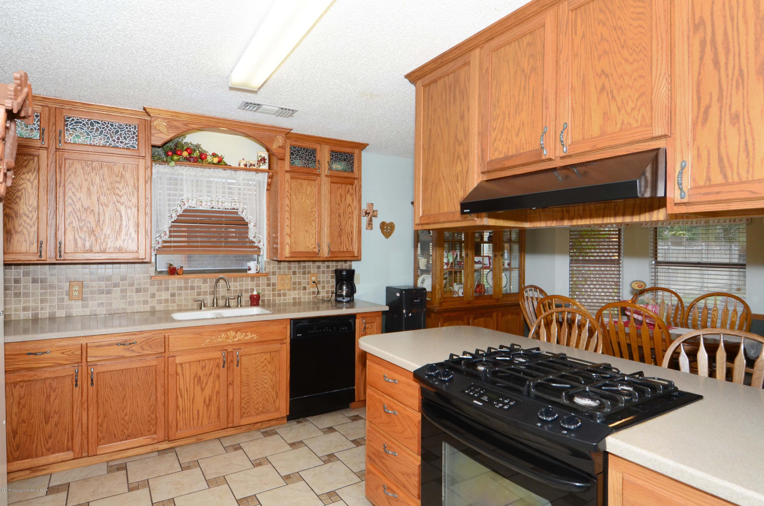 8104 Leah Trail Amarillo, TX 79110 - Photo 3 of 22 a kitchen with a stove a sink and a microwave