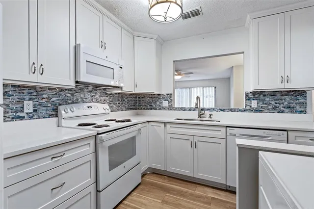 a kitchen with white cabinets stainless steel appliances and sink