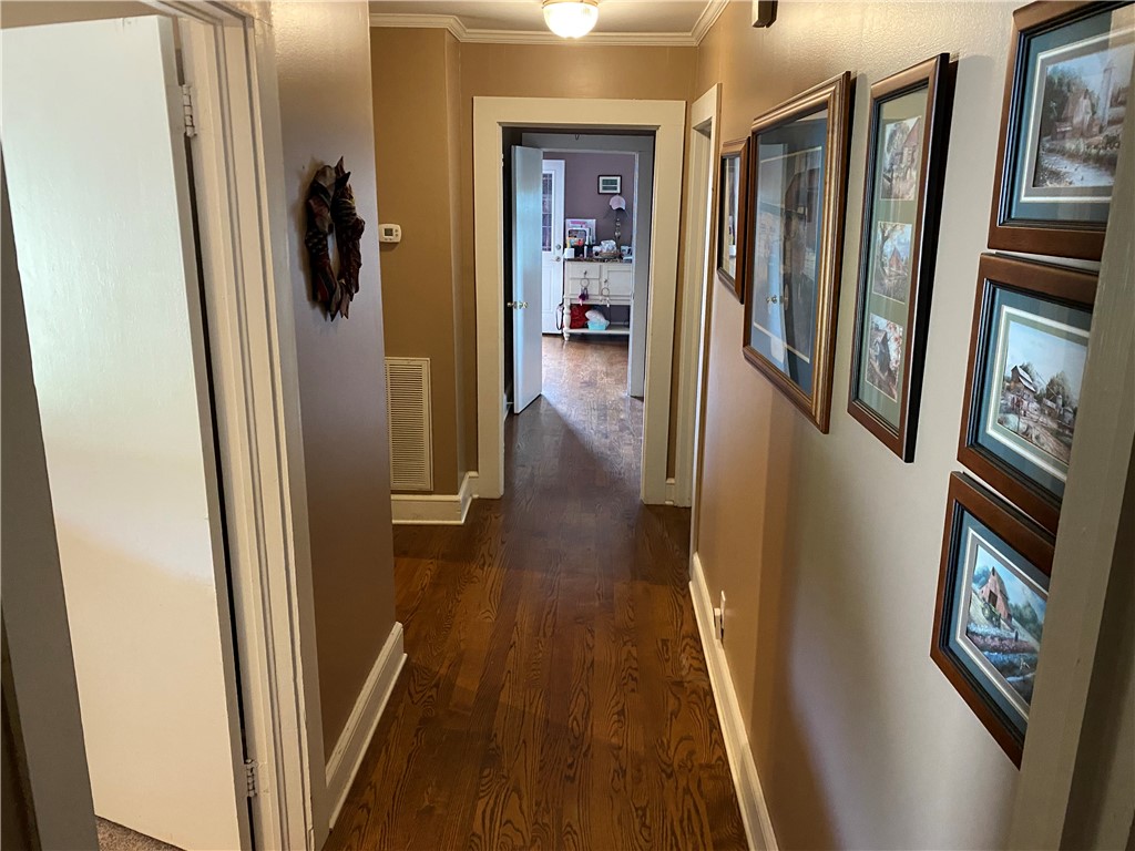 3 Heyward Avenue Honea Path, SC 29654 - Photo 12 of 35 Elegant hallway with rich wood flooring leads to bright living spaces, offering seamless flow and timeless appeal.