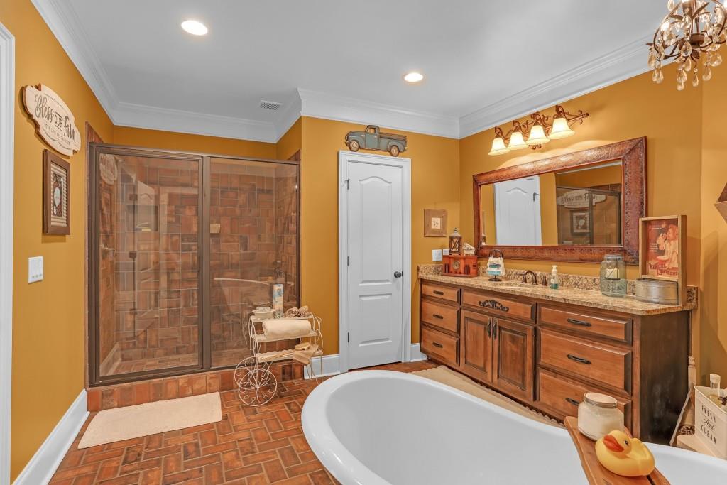 3386 Chandler Road Good Hope, GA 30641 - Photo 60 of 96 a bathroom with a double vanity sink a toilet a mirror and shower