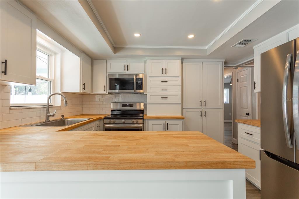 2021 Valley Drive Dunedin, FL 34698 - Photo 13 of 79 a kitchen with stainless steel appliances granite countertop a refrigerator a stove a sink and a microwave