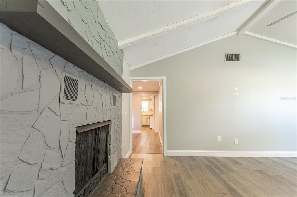 2021 Valley Drive Dunedin, FL 34698 - Photo 20 of 79 a view of an empty room with wooden floor and a fireplace