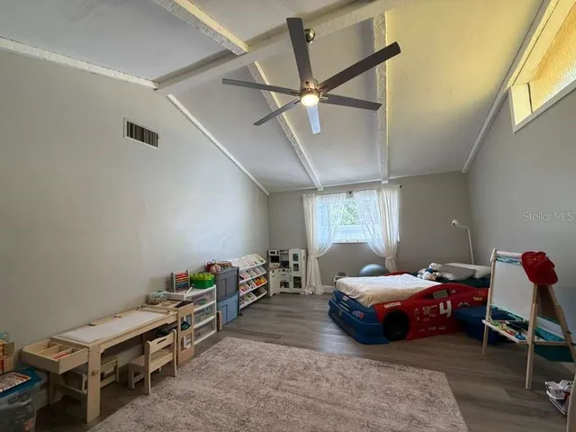 a bedroom with a bed and a ceiling fan