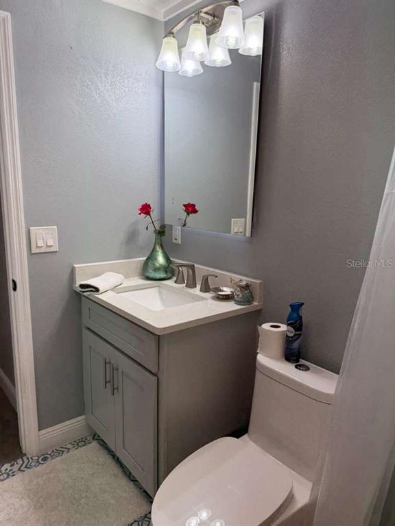 2021 Valley Drive Dunedin, FL 34698 - Photo 36 of 79 a bathroom with a granite countertop sink a toilet and a mirror