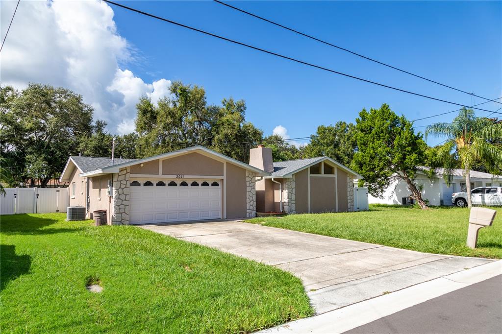 2021 Valley Drive Dunedin, FL 34698 - Photo 43 of 79 a front view of a house with a yard and garage
