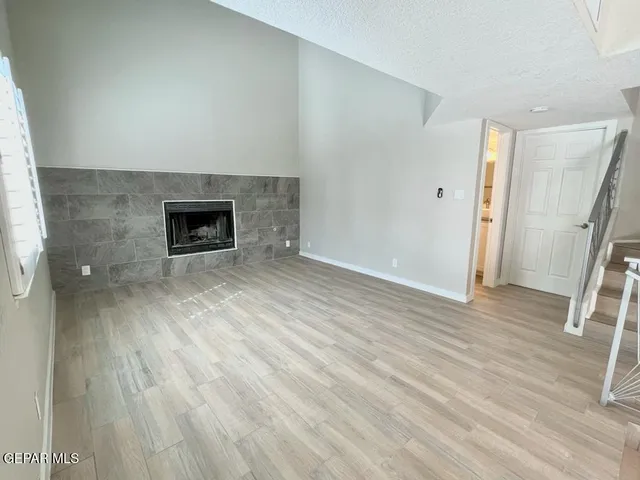 an empty room with wooden floor and staircase