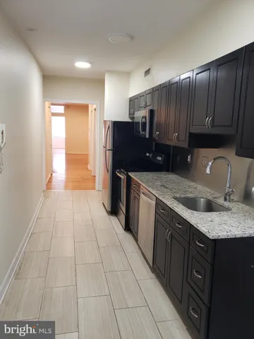 a kitchen with stainless steel appliances granite countertop a sink stove and cabinets