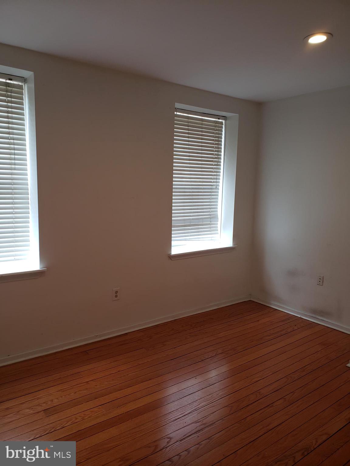 319 Market Street, Unit 3 Philadelphia, PA 19106 - Photo 3 of 14 an empty room with wooden floor and windows