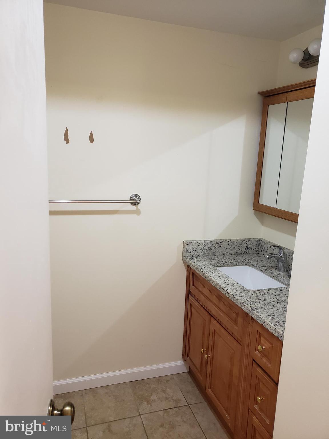 319 Market Street, Unit 3 Philadelphia, PA 19106 - Photo 7 of 14 a bathroom with a granite countertop sink and a mirror