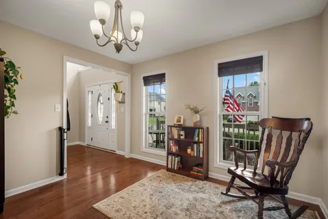 a view of a hallway with wooden floor and windows