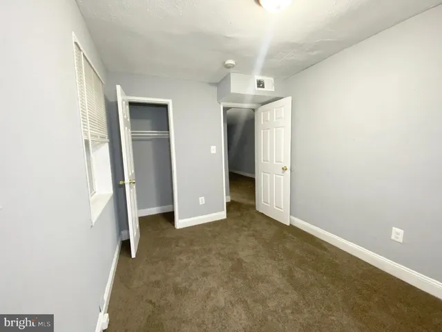 an empty room with closet and windows