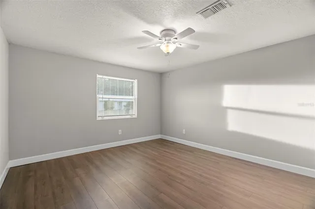 a view of a room with wooden floor and ceiling fan