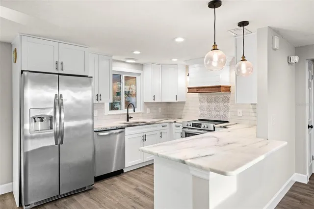 a kitchen with stainless steel appliances granite countertop a stove and a sink