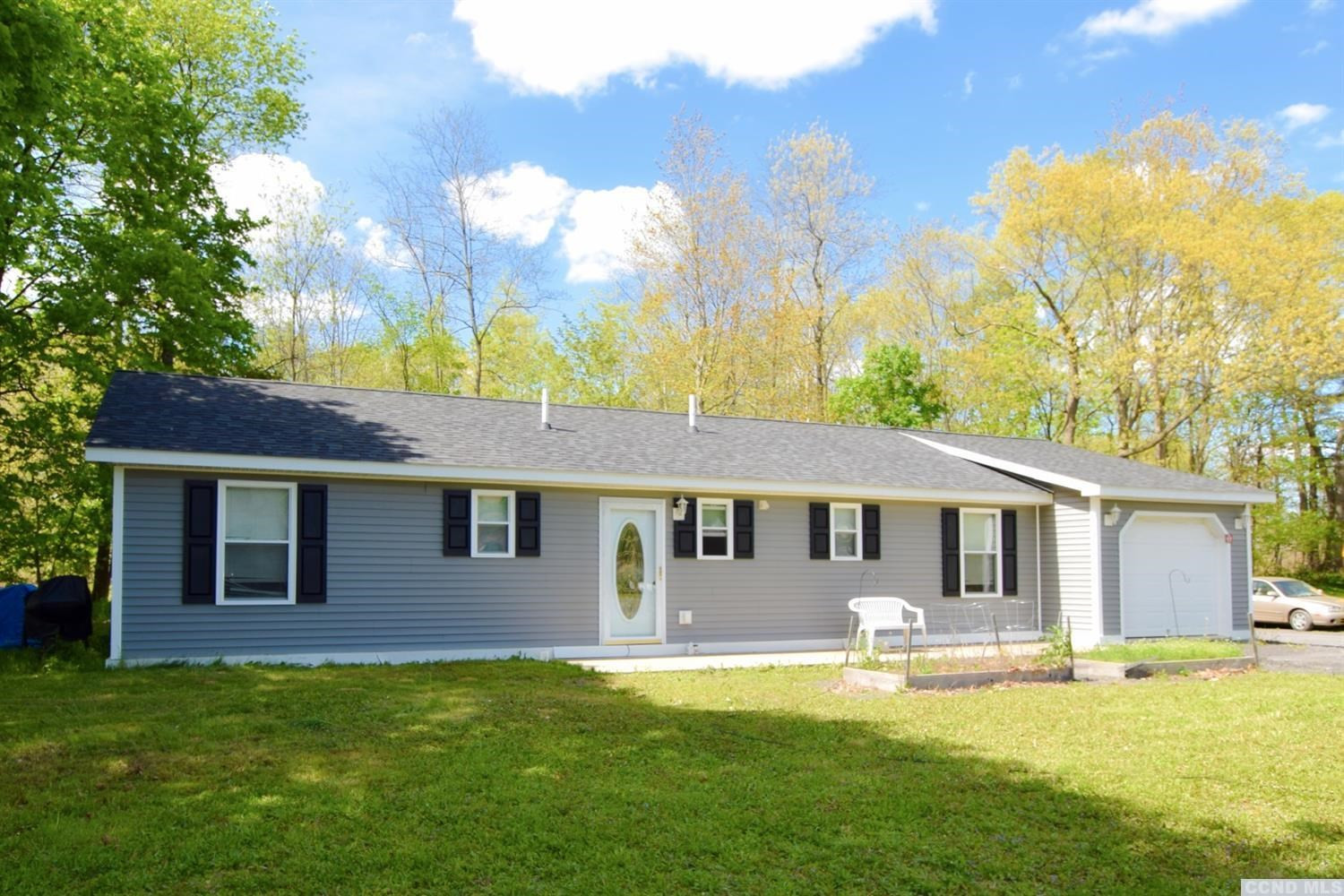 a front view of a house with yard and swimming pool