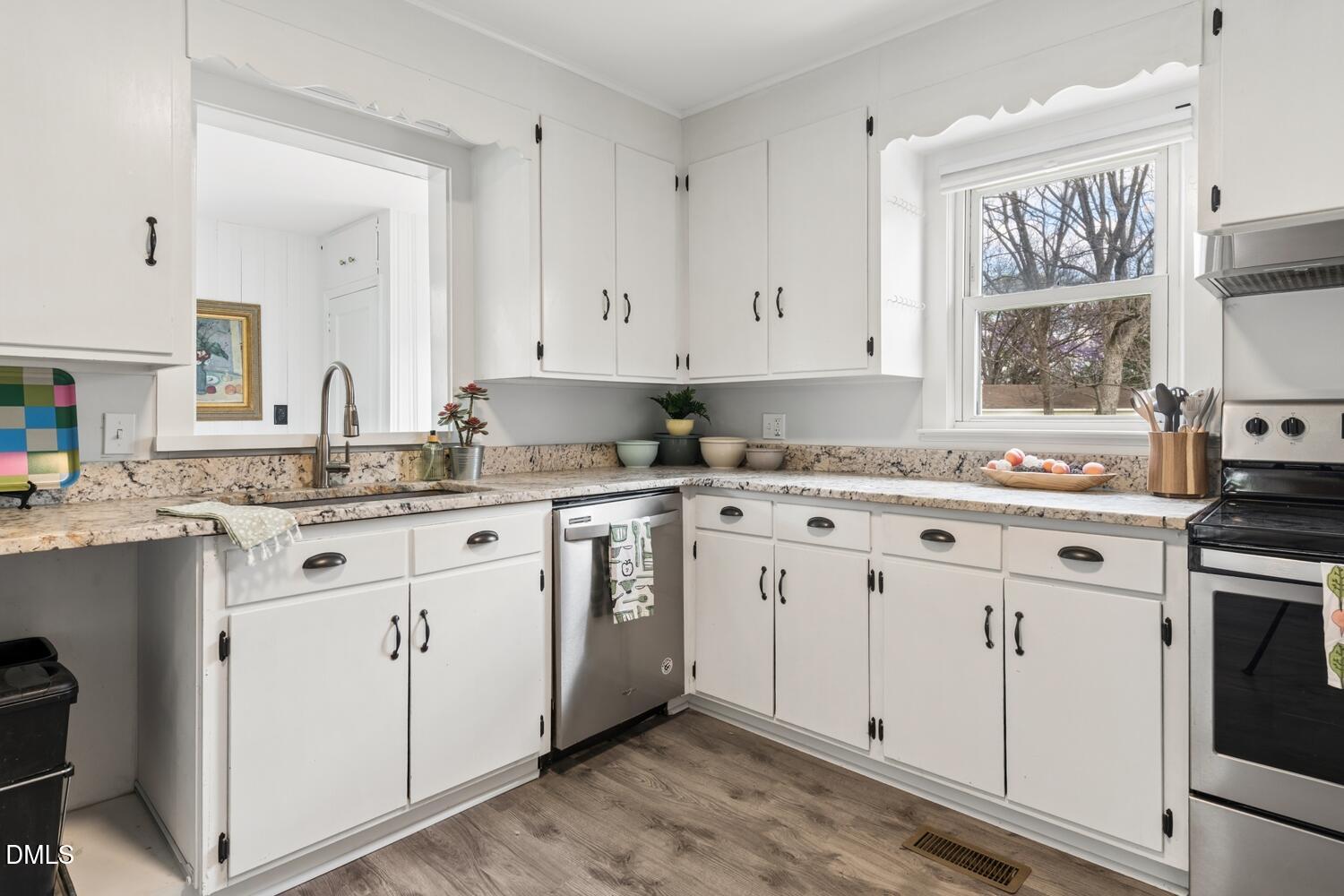 414 South Maple Street Graham, NC 27253 - Photo 9 of 42 a kitchen with granite countertop white cabinets white appliances a sink and a window