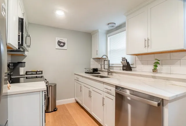 a kitchen with stainless steel appliances granite countertop a sink stove and cabinets