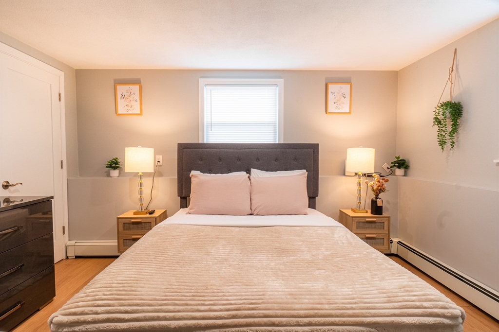 33 Bristow Street, Unit 2 Saugus, MA 01906 - Photo 12 of 21 a large bed sitting in a bedroom next to a window with potted plant