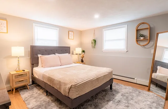 a bedroom with a bed a mirror and a window