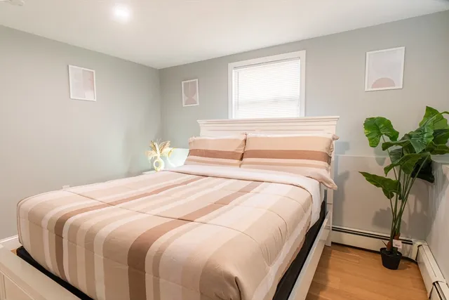 a bedroom with a bed potted plant and a window