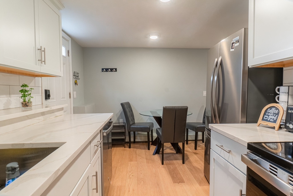 33 Bristow Street, Unit 2 Saugus, MA 01906 - Photo 2 of 21 a kitchen that has a sink chairs and a refrigerator