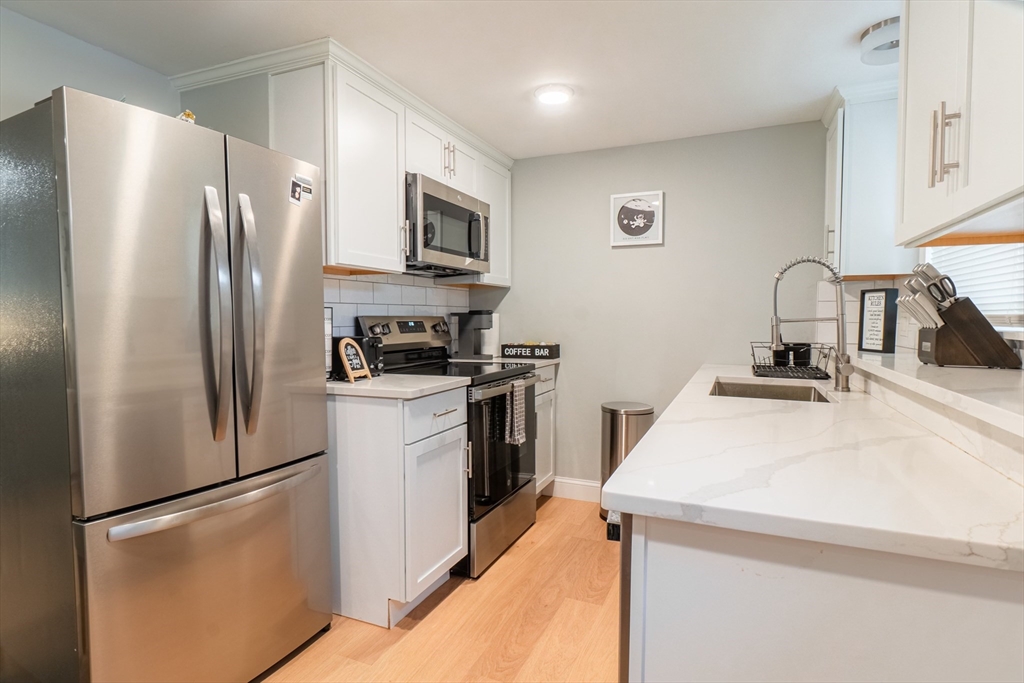 33 Bristow Street, Unit 2 Saugus, MA 01906 - Photo 5 of 21 a kitchen with stainless steel appliances a refrigerator sink and microwave