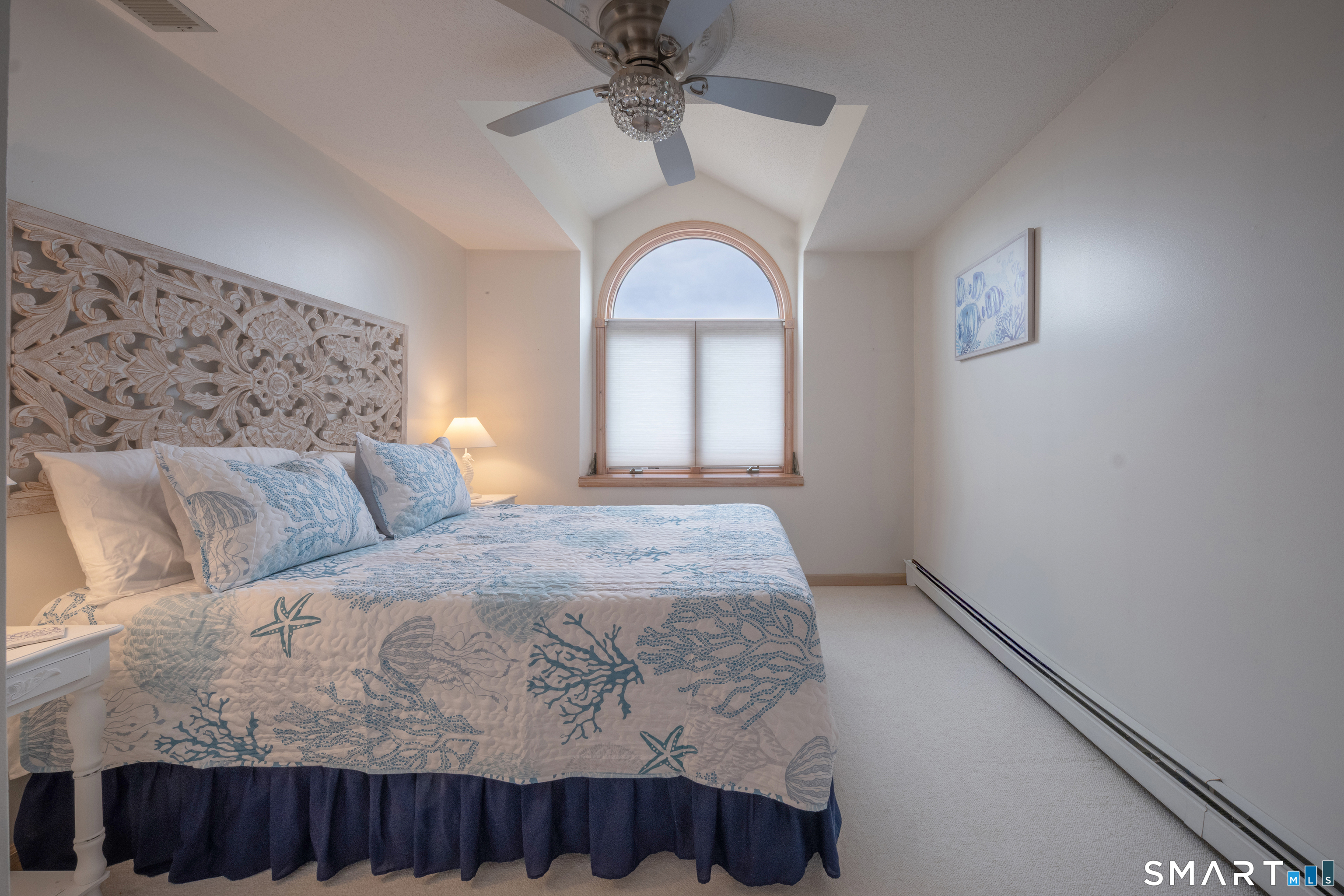 5 A Loop Road, Unit 5A Clinton, CT 06413 - Photo 21 of 37 a bedroom with a large bed and a chandelier