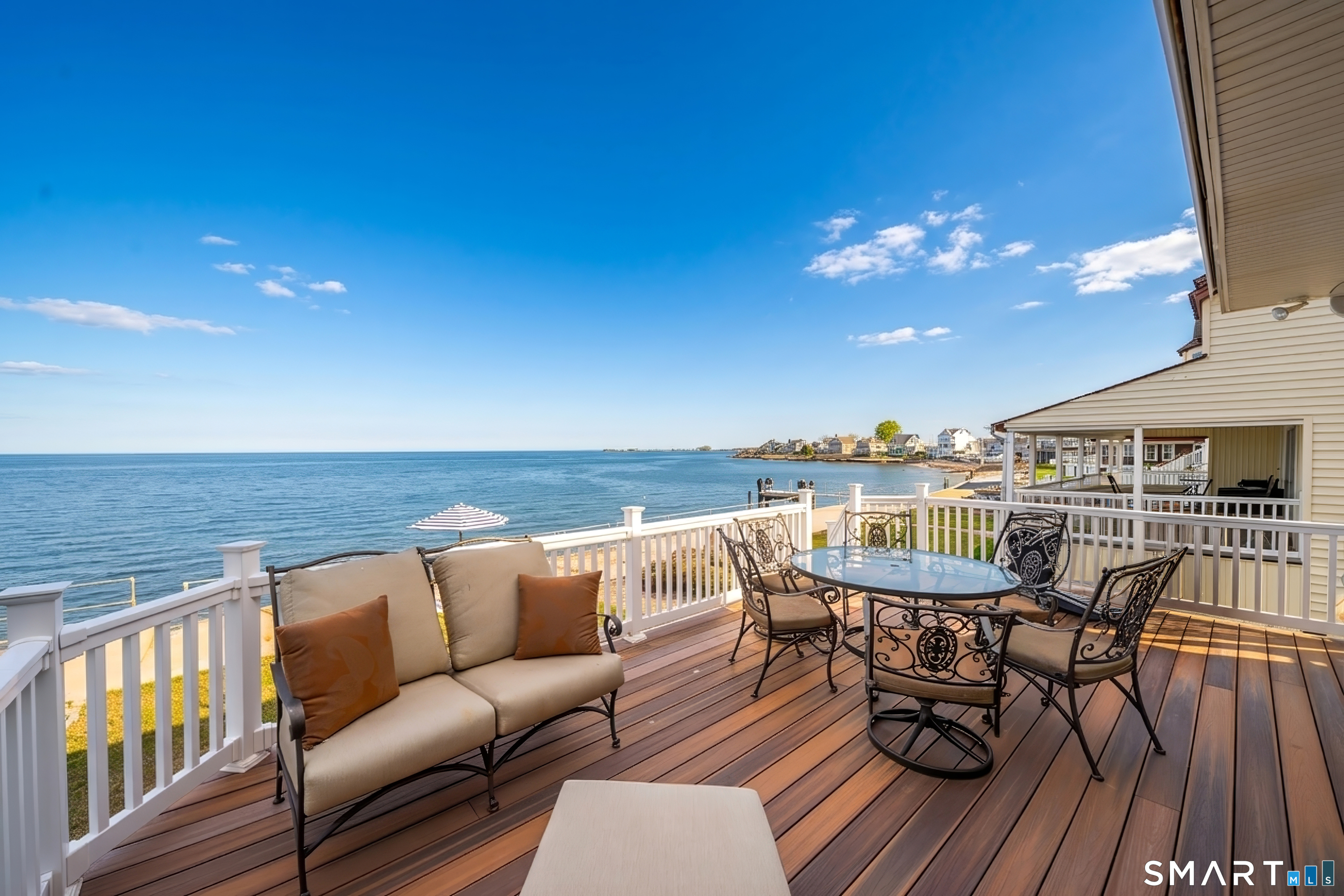 5 A Loop Road, Unit 5A Clinton, CT 06413 - Photo 6 of 37 a view of a balcony with dining table and chairs with wooden floor