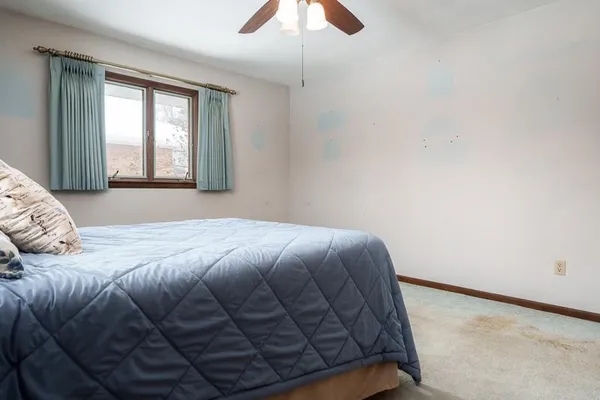 a bed sitting in a bedroom next to a window