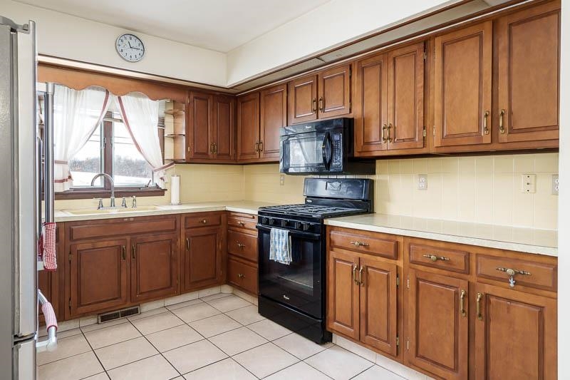 1126 Main Street Pecatonica, IL 61063 - Photo 9 of 40 a kitchen with stainless steel appliances granite countertop a stove a sink and a microwave