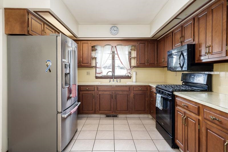 1126 Main Street Pecatonica, IL 61063 - Photo 10 of 40 a kitchen with a refrigerator a sink and cabinets