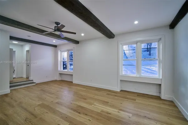 a view of empty room with wooden floor and fireplace