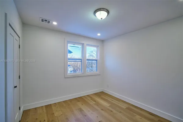 wooden floor in an empty room with a window