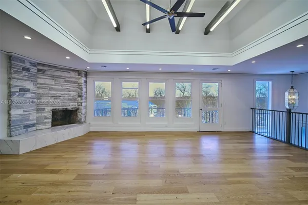 a view of empty room with wooden floor and fireplace