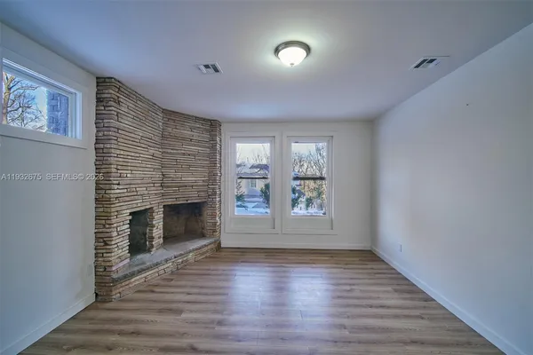 a living room with furniture a table wooden floor and a rug