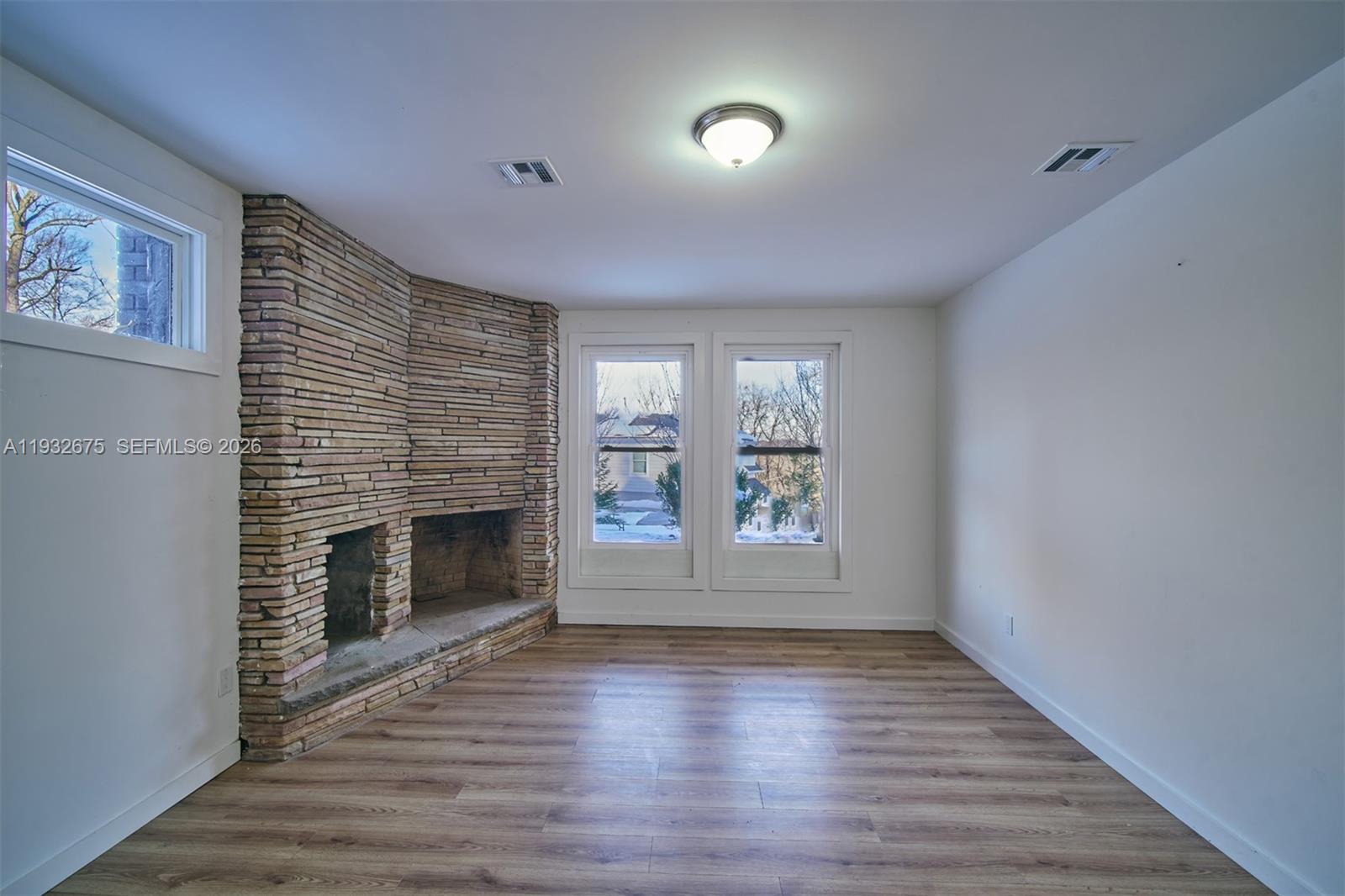 189 McNamara Road Spring Valley, NY 10977 - Photo 35 of 47 an empty room with wooden floor fireplace and windows